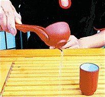 Using the tongs to empty the cups.